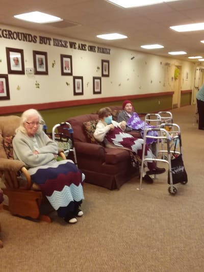 Residents in a cozy seating area with blankets