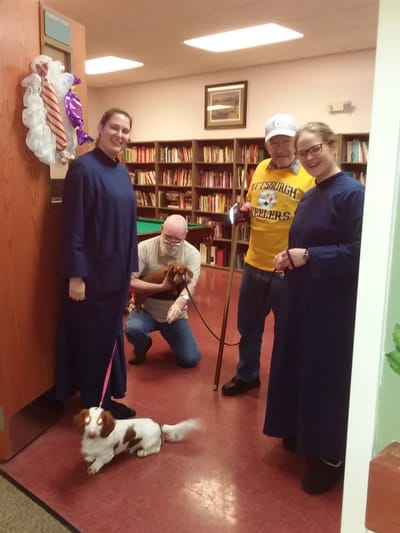 Residents and staff smiling together in a common area