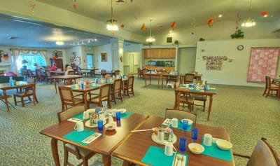 Dining room set up for a meal with residents seated