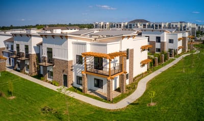 Exterior view of a senior living facility surrounded by green space