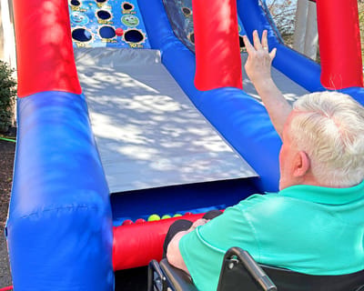 Resident playing a carnival-style game at an outdoor event