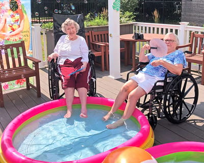 Two residents enjoying a summer pool activity outdoors