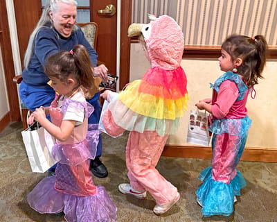 Residents interacting with children in colorful costumes