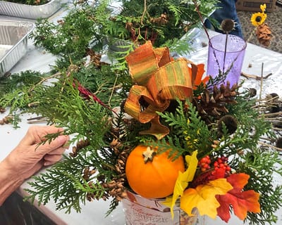 Residents creating fall-themed floral arrangements