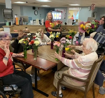 Residents participating in a flower arranging activity indoors
