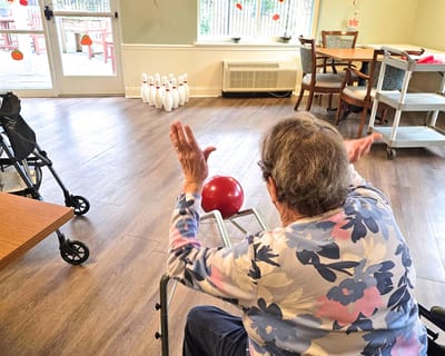 Resident participating in a bowling activity in the facility