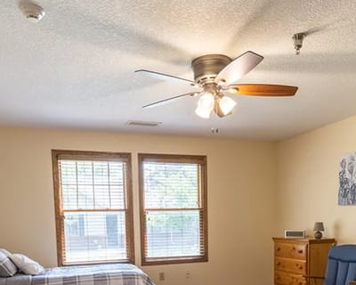 Brightly lit resident room with windows and furniture