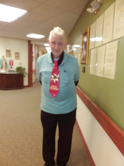 Resident in a festive tie standing in a hallway