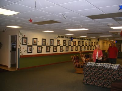 Residents walking through an interior hallway with photos.