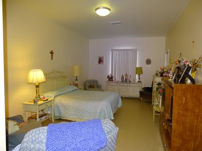 A private resident room with two beds and personal items.