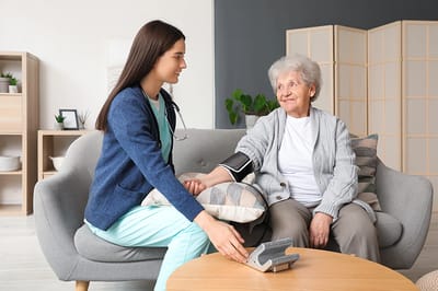 Nurse taking blood pressure of senior resident