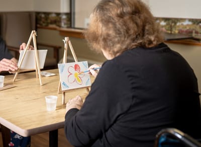 Residents engaged in an art activity at a table