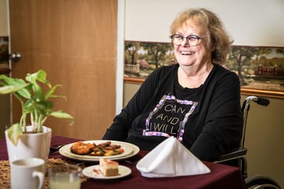 Resident enjoying a meal with a smile