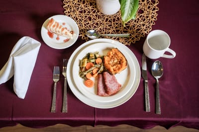 Plated meal featuring vegetables and dessert on a dining table