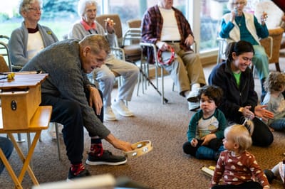 Residents and children engaging in a music activity