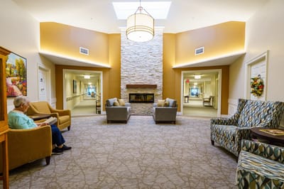 A well-furnished common area with a resident reading