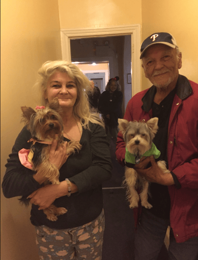 Residents holding dogs in a hallway setting
