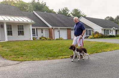 Resident walking a dog near cottage homes