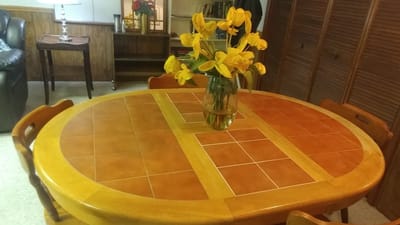 Cozy dining table with a vase of yellow flowers