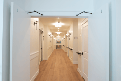 Bright hallway with light fixtures and wooden flooring