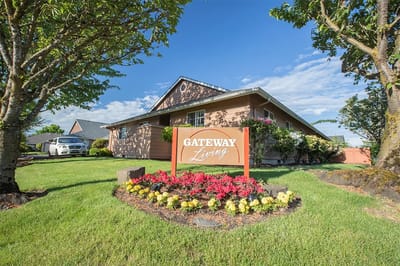 Exterior view of Gateway Living with flower beds