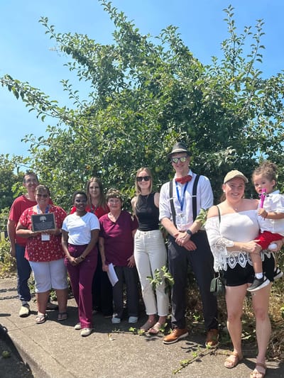 Group of staff and residents outdoors posing for a photo