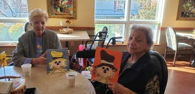 Residents painting in a common area with festive decorations