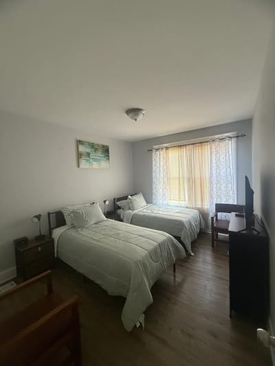 A cozy resident room with two beds and a TV