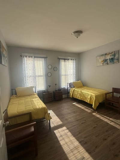 A shared resident room with two beds and natural light