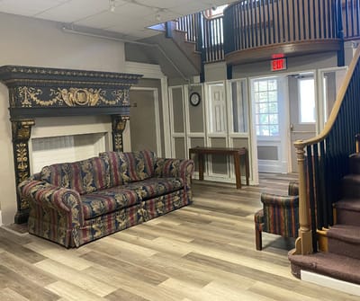 Cozy common area with a decorative sofa and staircase