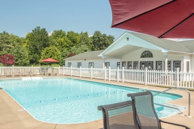 Swimming pool area with lounge chairs and umbrella