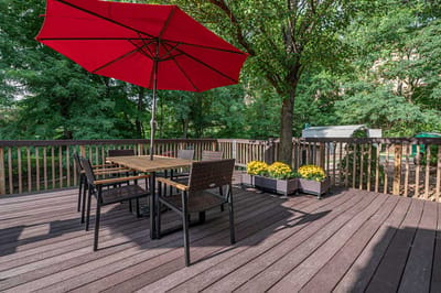 Outdoor seating area with a red umbrella and flowers
