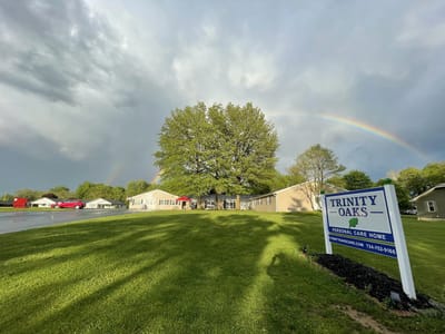 Facility entrance with sign and rainbow in the background
