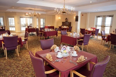 Dining room set up for a meal with tables and chairs