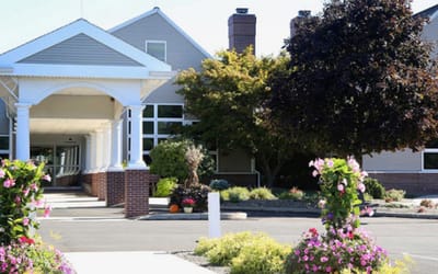 Front entrance of a senior living facility with landscaped gardens