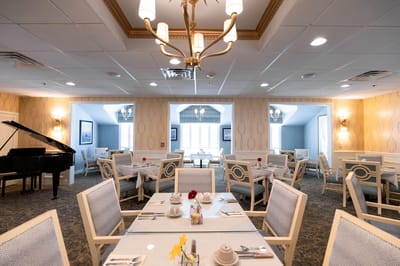 Elegant dining room set for a meal with piano