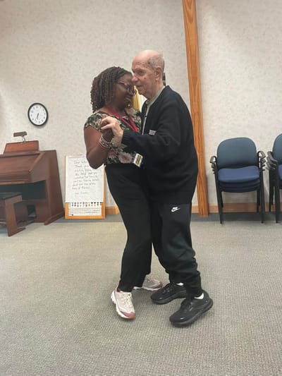 A man and woman dancing in a common area