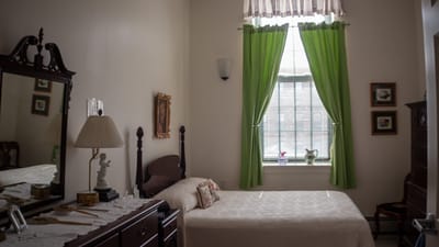 Cozy resident room with green curtains and a bed