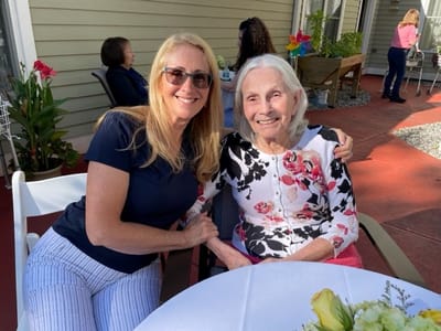 Staff member and resident smiling together outdoors