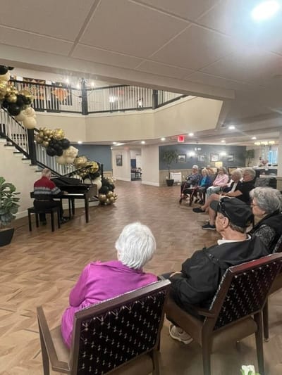 Residents enjoying a piano performance in the common area