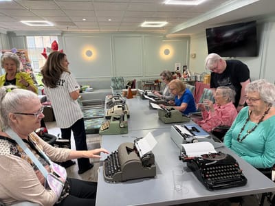 Residents engaging in a typewriter activity in a common area