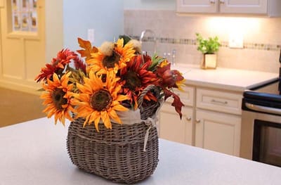 A decorative basket of sunflowers on a kitchen counter