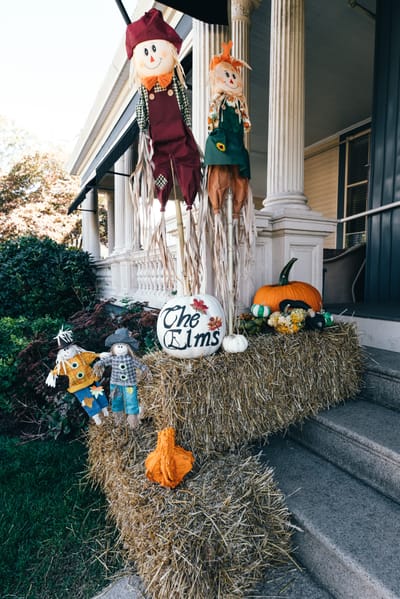 Decorative fall display with scarecrows and pumpkins at the facility entrance