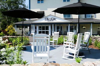 Outdoor seating area with rocking chairs near the entrance
