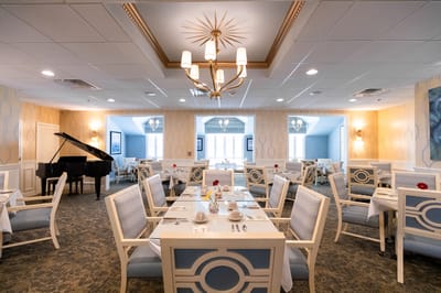 Bright dining area with a piano and well-set tables