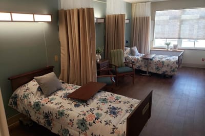 Private resident room with two beds and seating