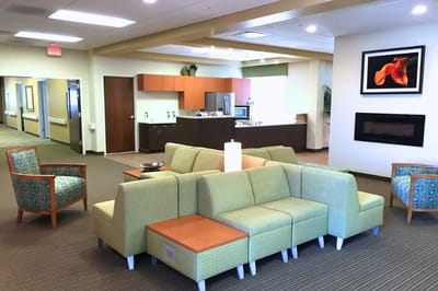 Bright, modern common area with seating and kitchen in background