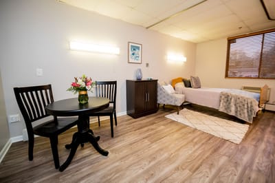 Cozy resident room with a bed and small dining table