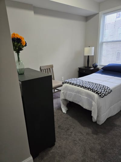 Private resident room with bed and chair