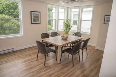 Light-filled dining area with a wooden table and chairs